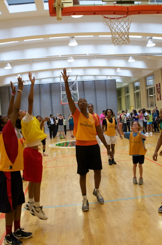 boys holding hands up and reaching up in the air at basketball