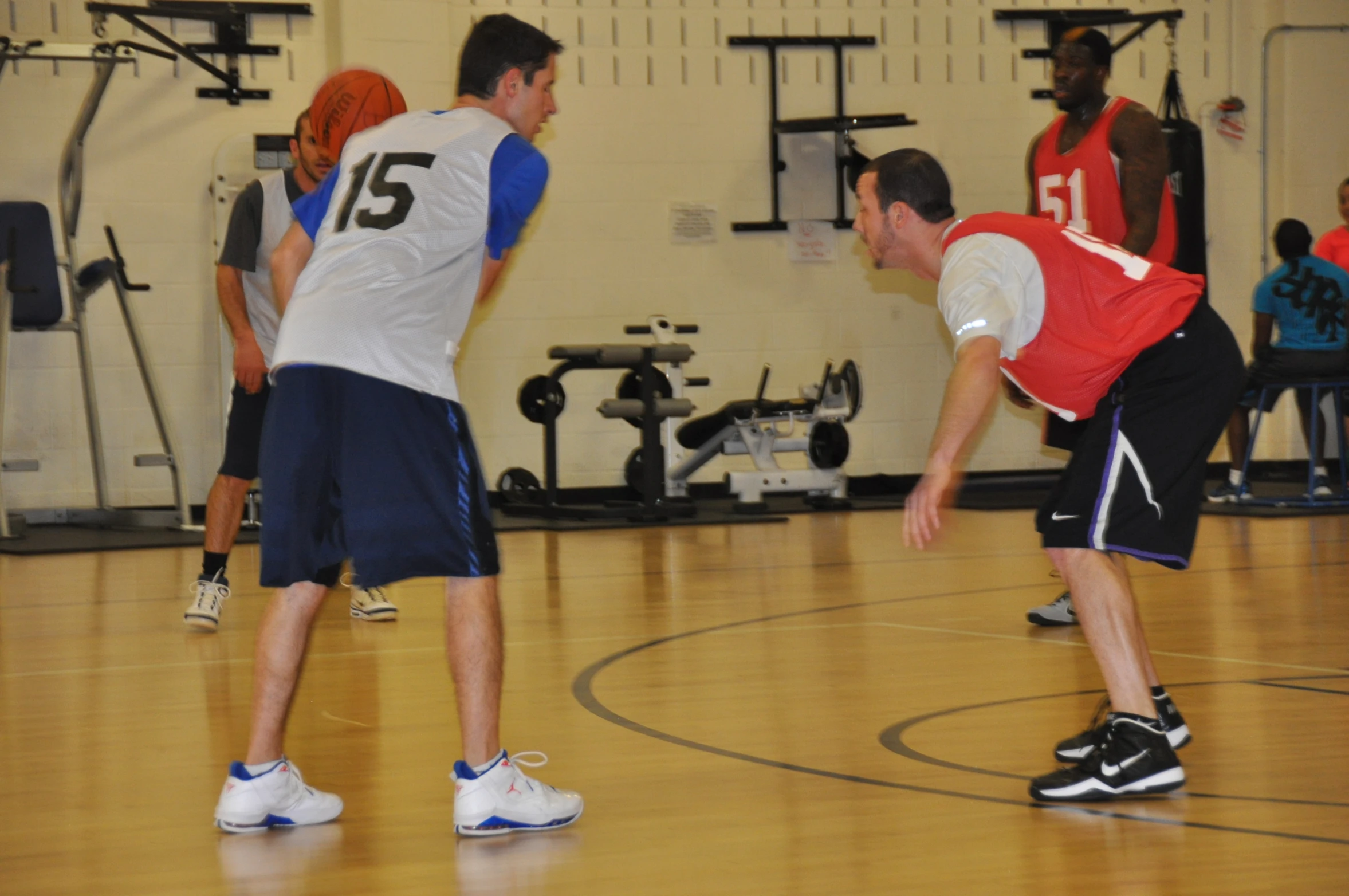 young men playing in a gym on an indoor basketball court