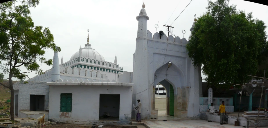 a white building with a green door and a white domed dome