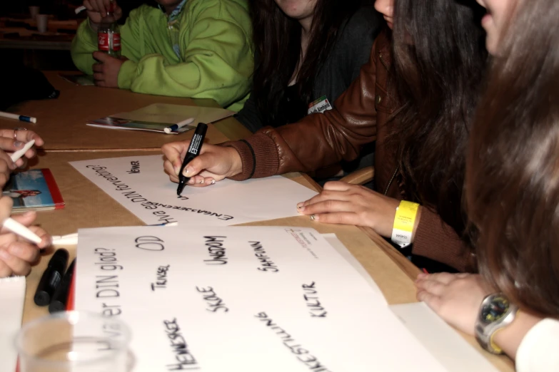 three people signing papers at a long table