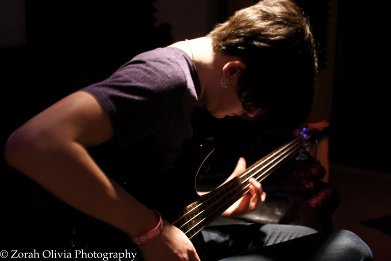 a person in a dark room playing a bass