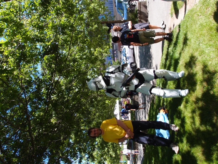 a man dressed as storm trooper poses by some people