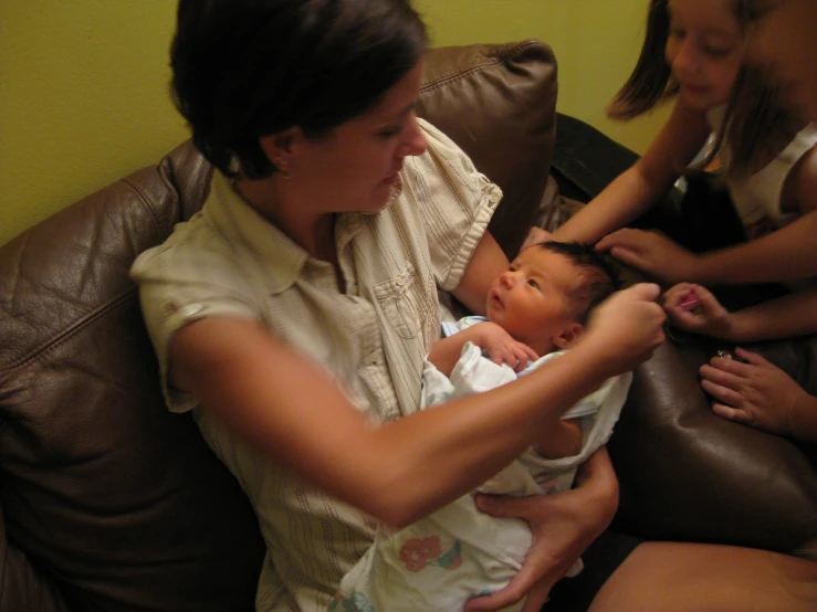 a woman holding a baby on top of her stomach