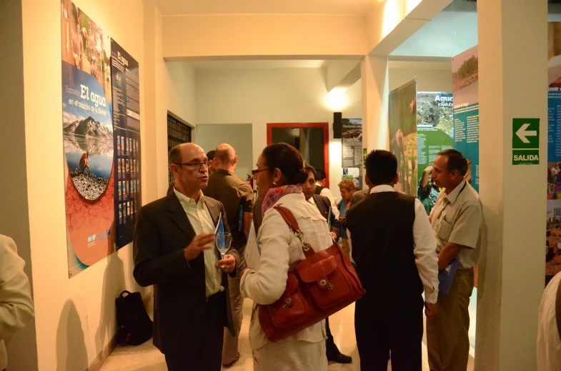 several people in a corridor looking at a poster