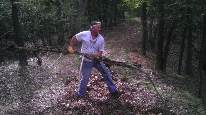 a man carrying two large pieces of wood