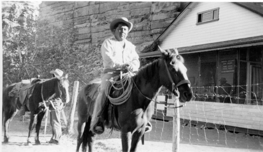 a man wearing a hat is sitting on a horse