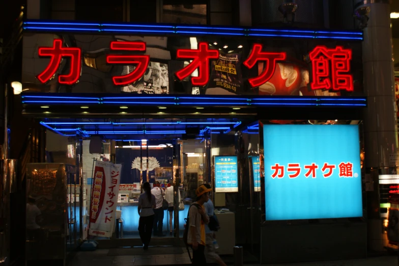 neon sign with two people standing in front of it