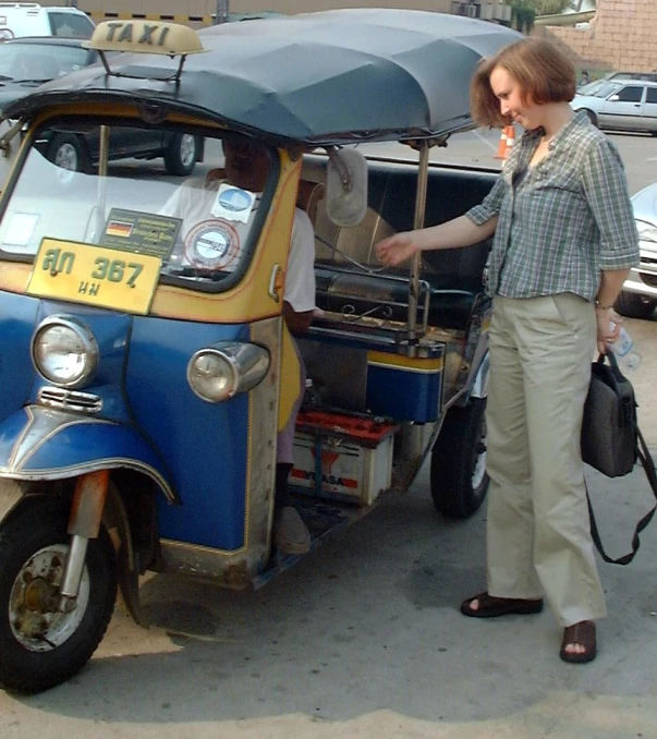 a woman is standing next to her car selling merchandise