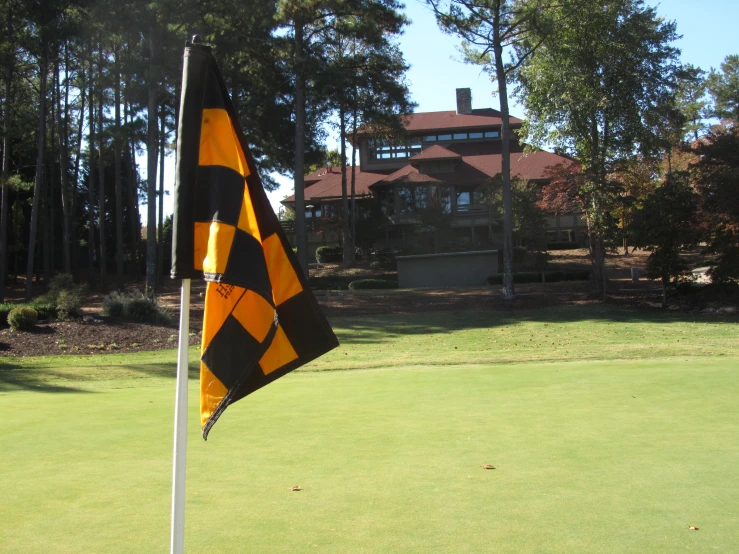 a black and yellow flag next to a green field