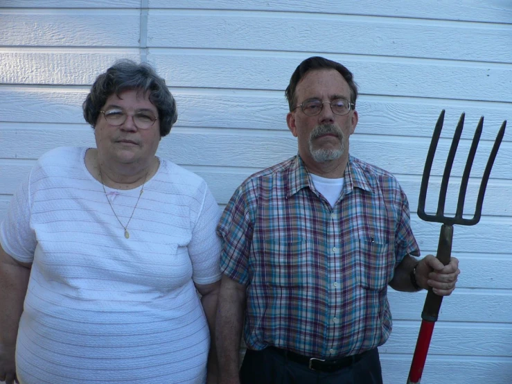 an older woman and man are holding pitchforks
