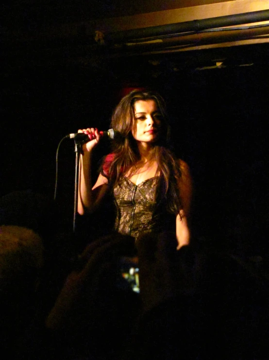 a woman standing on stage holding a microphone