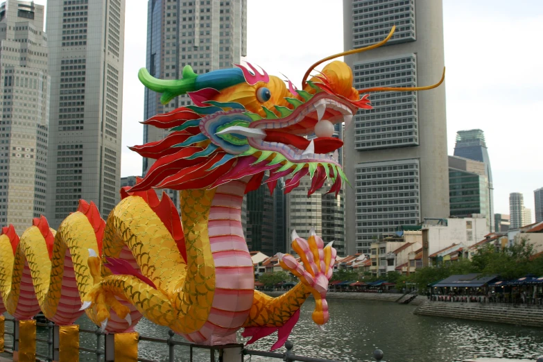 a very colorful sculpture in front of a large body of water