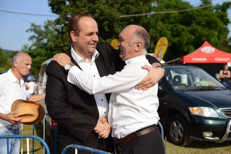 two men hugging each other while holding their arms around each other