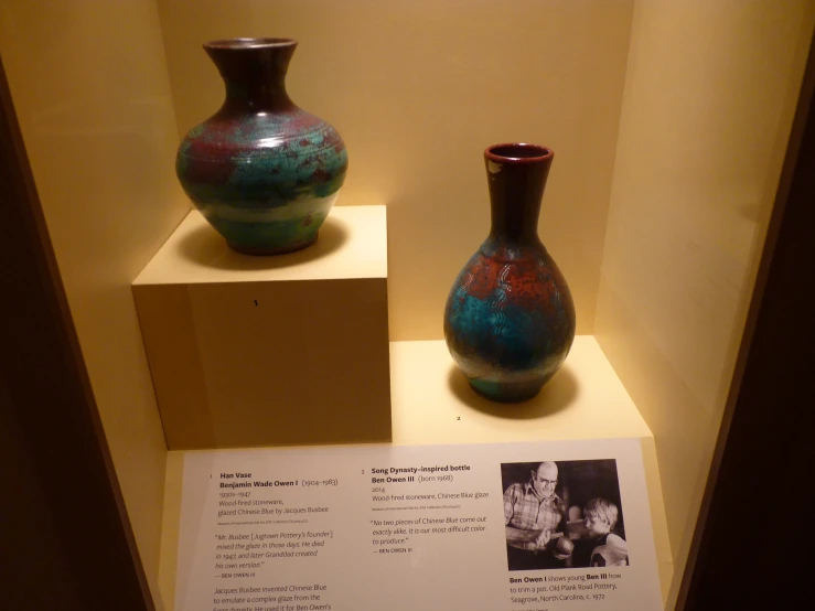 a display in a room with several vases on display