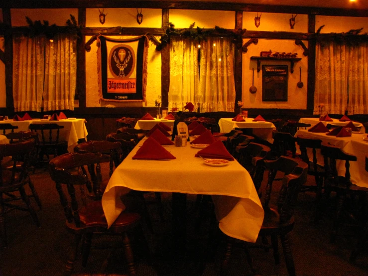 several tables with place settings in a dining room