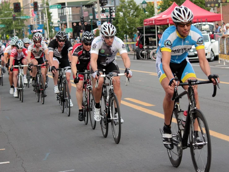 several bikers are coming down the street during a race