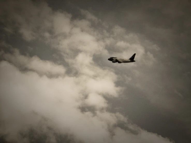 a plane is flying thru the clouds under a cloudy sky