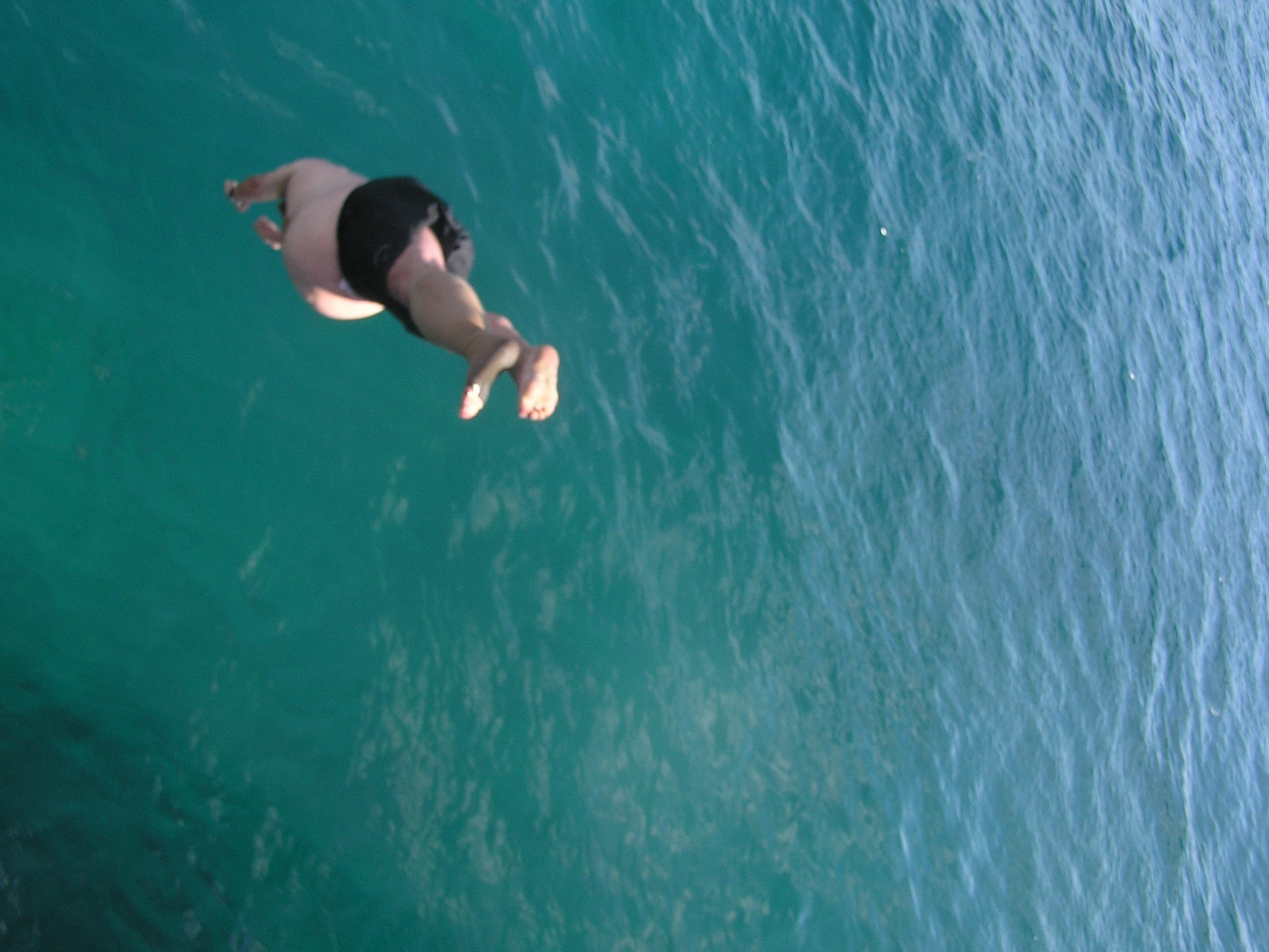 a person diving into some clear blue water