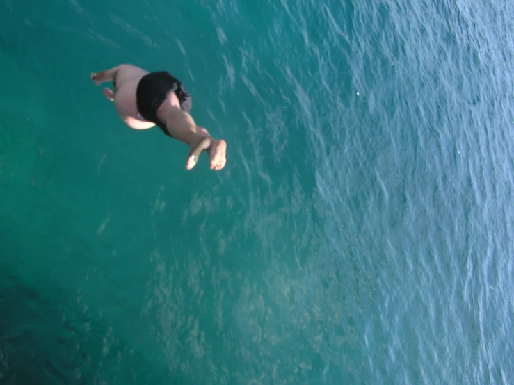 a person diving into some clear blue water
