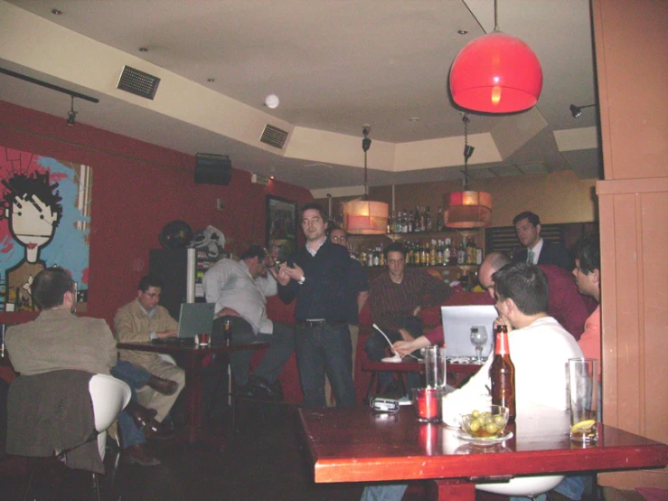 a crowded room with a man holding a drink