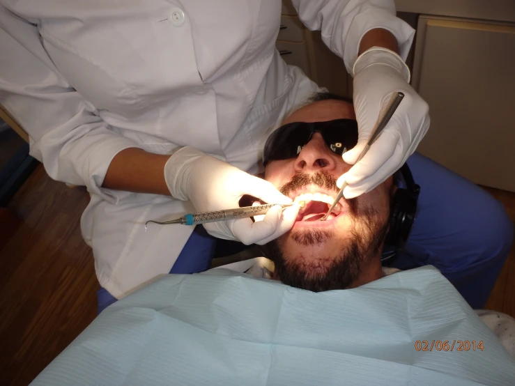 a man laying on top of a table in a dentist chair