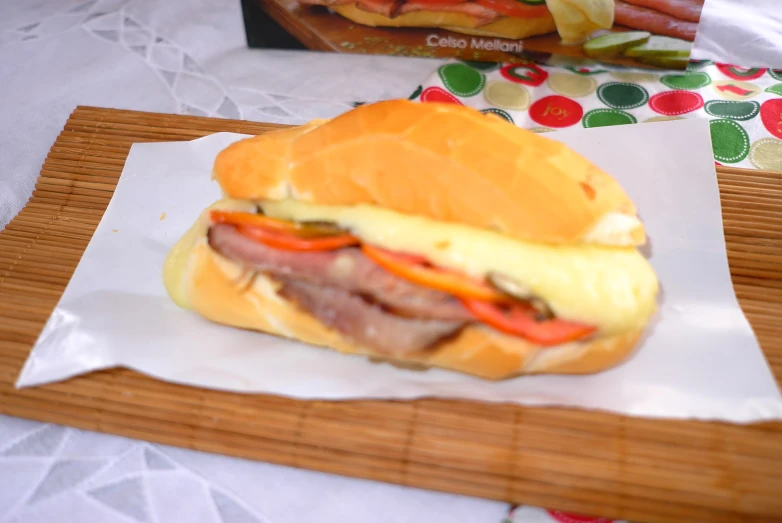 a sandwich made from bacon and cheese, on top of a  board
