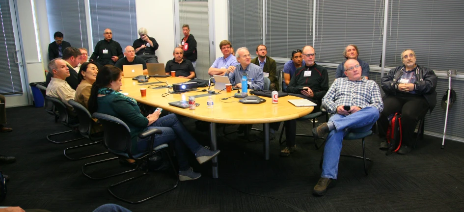 a group of people gathered around a table in a meeting room