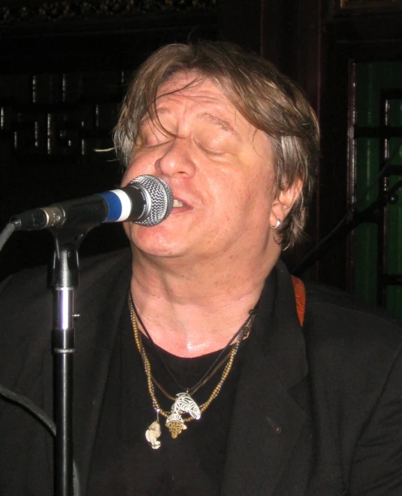 the musician is singing into a microphone and singing