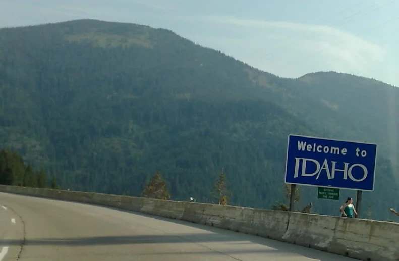 the welcome to idaho sign is located beside the mountains