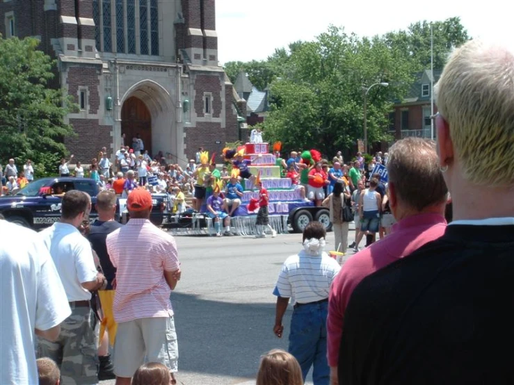 people walking on street with floats and a crowd