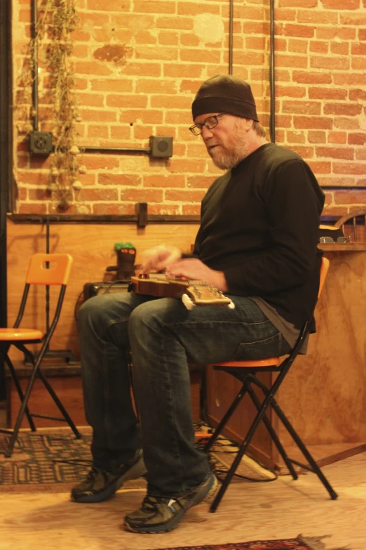 the man is sitting on his chair reading a book