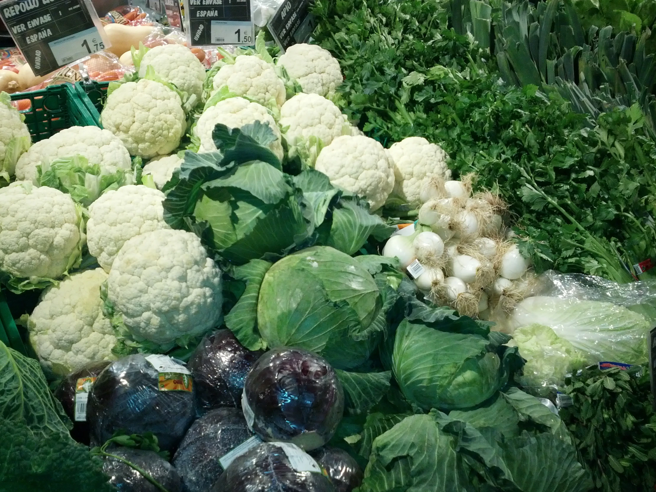 a vegetable stand at the market with several heads of cauliflower