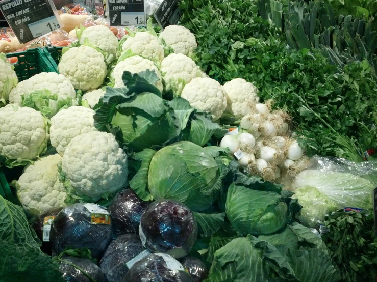 a vegetable stand at the market with several heads of cauliflower
