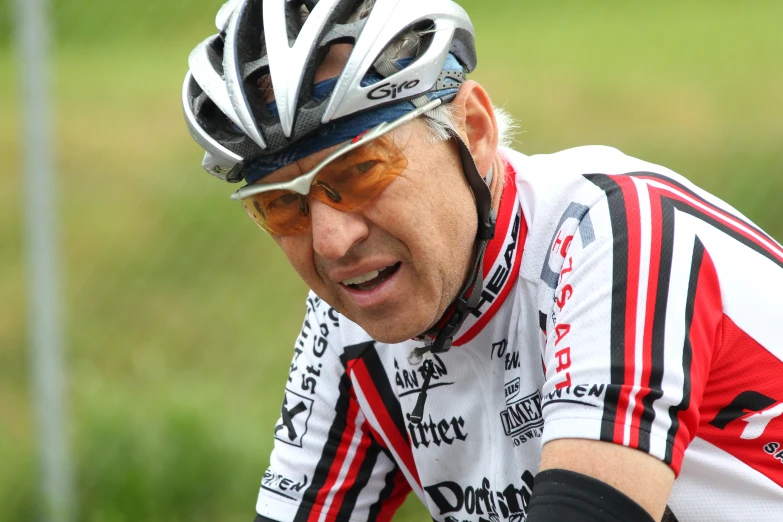 a man in cycling gear is leaning on the edge of his bike