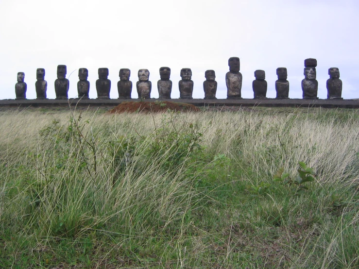 several large statues of different sizes near a grassy field