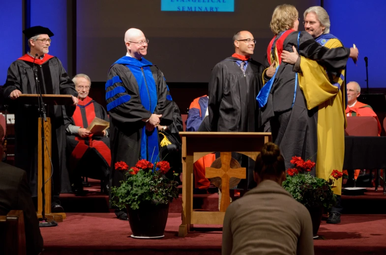 a group of people at graduation with a speaker