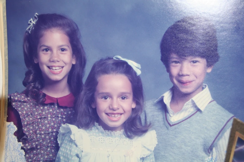 two boys and a girl pose for a po in a school picture frame