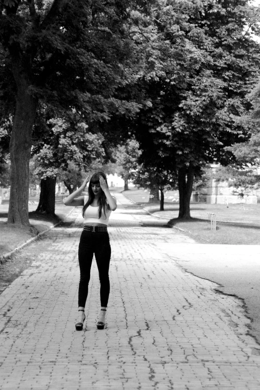 a woman is standing in the middle of a park