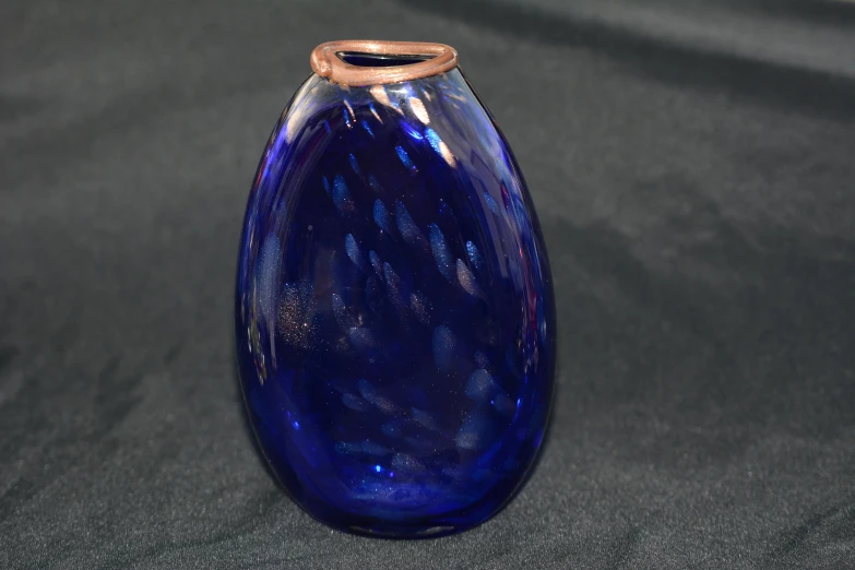 an blue glass vase on a table on display