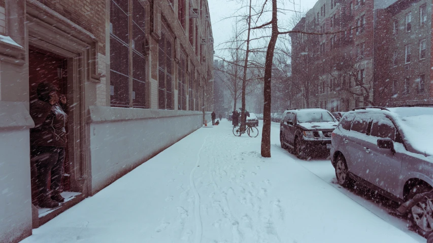 cars parked on a snowy sidewalk near buildings