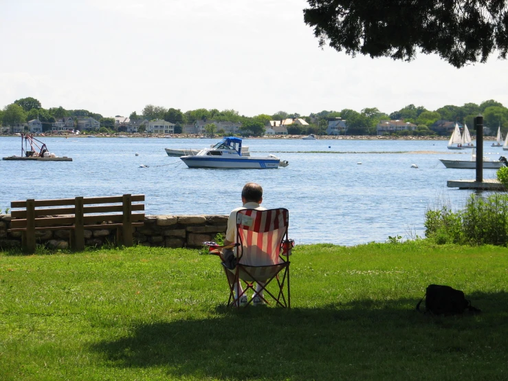 a person sitting in a chair with a view of the lake