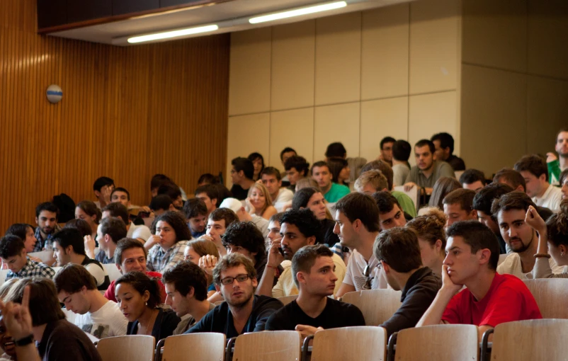 several people are seated in rows in the auditorium