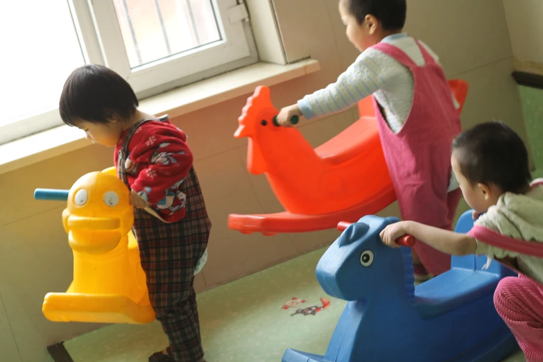 two children standing in a room with toys