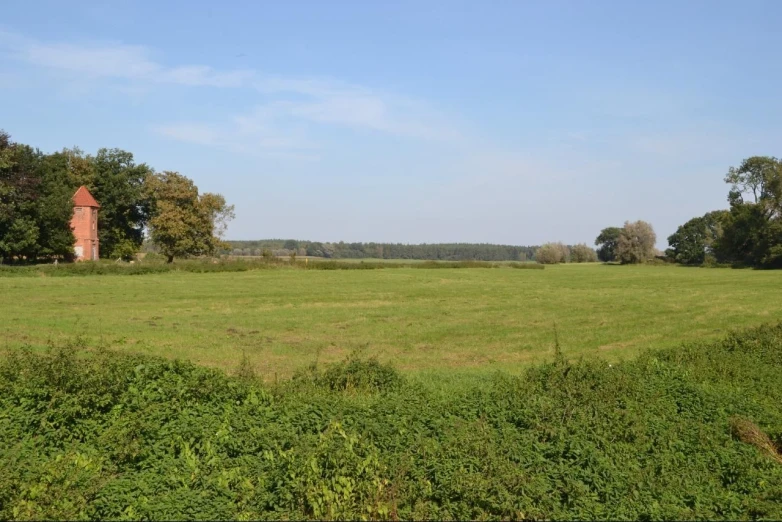 a farm field with a tower in the distance