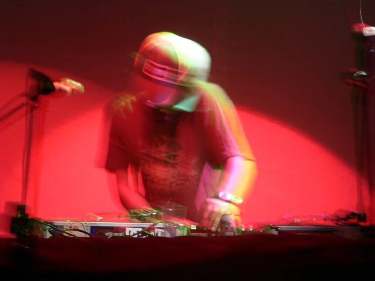 man in red light with dj equipment playing music