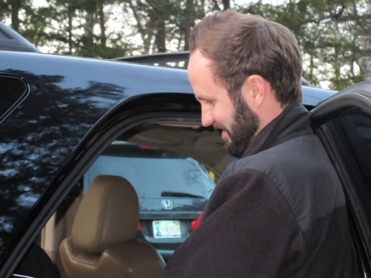 a man in a car is using his cell phone