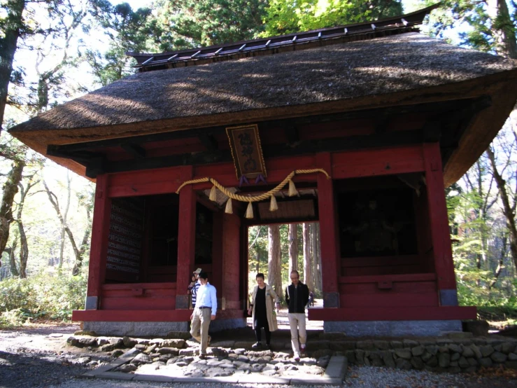 two people standing in front of a red shrine