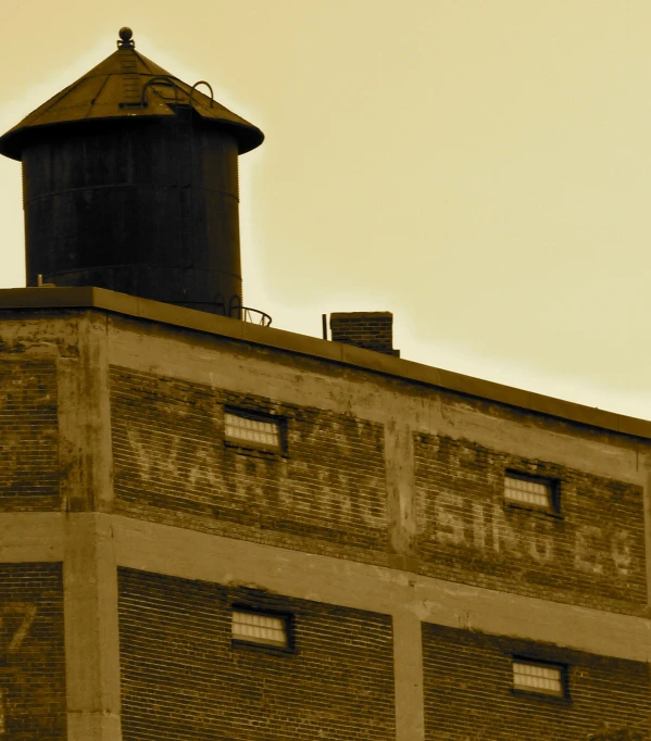 a tall brick building with a black tower on top