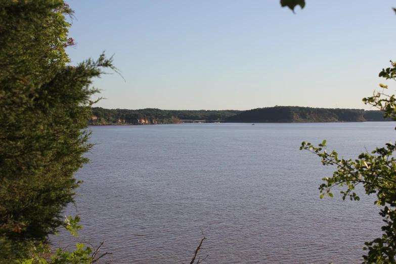 a lake in a wooded area with a boat out on it