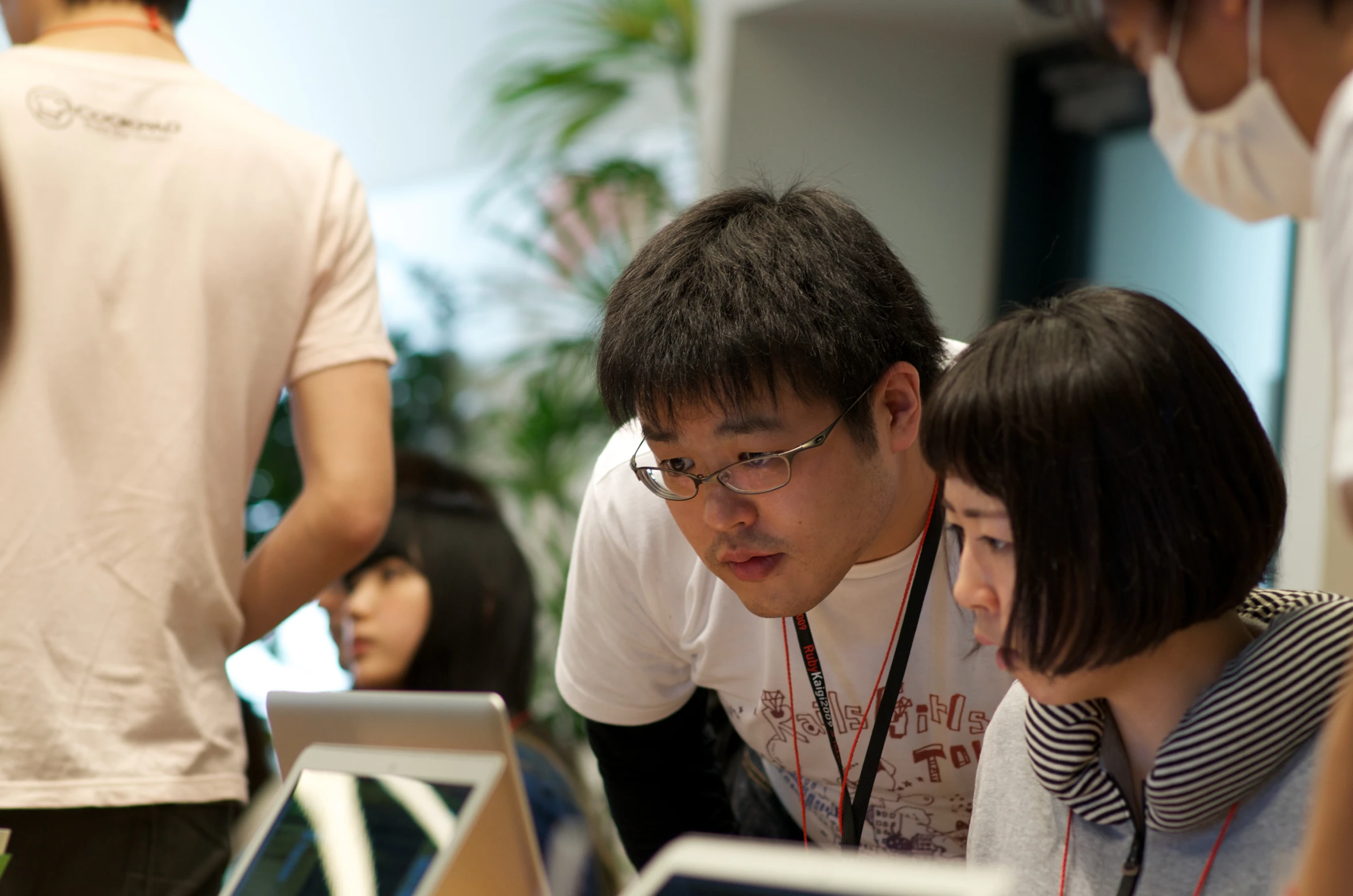 an asian man looking at his laptop screen